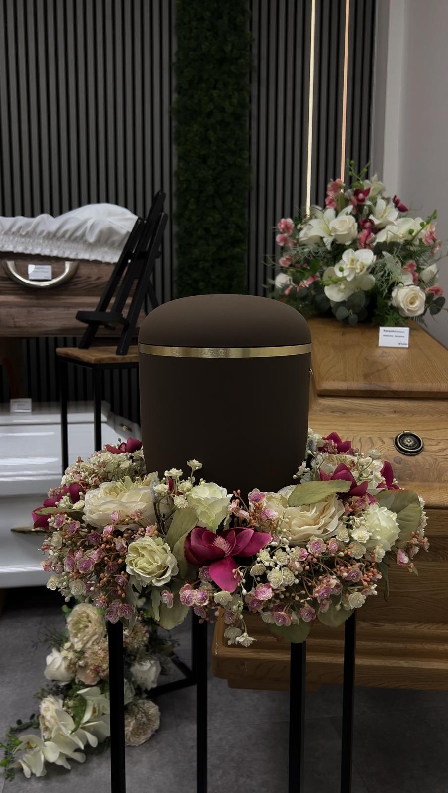 Urne mit Blumenkranz und Sarg im Ausstellungsraum von Bestattungen Kinderknecht Nürnberg